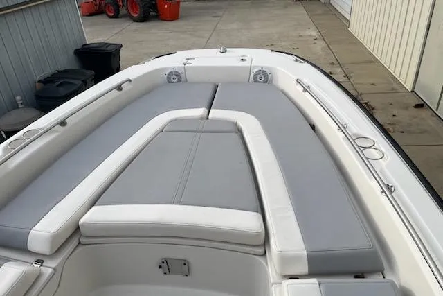 Slide: The Image of 2014 Boston Whaler Dauntless 240 boat with gray cushioned seating in a docked position. - 7