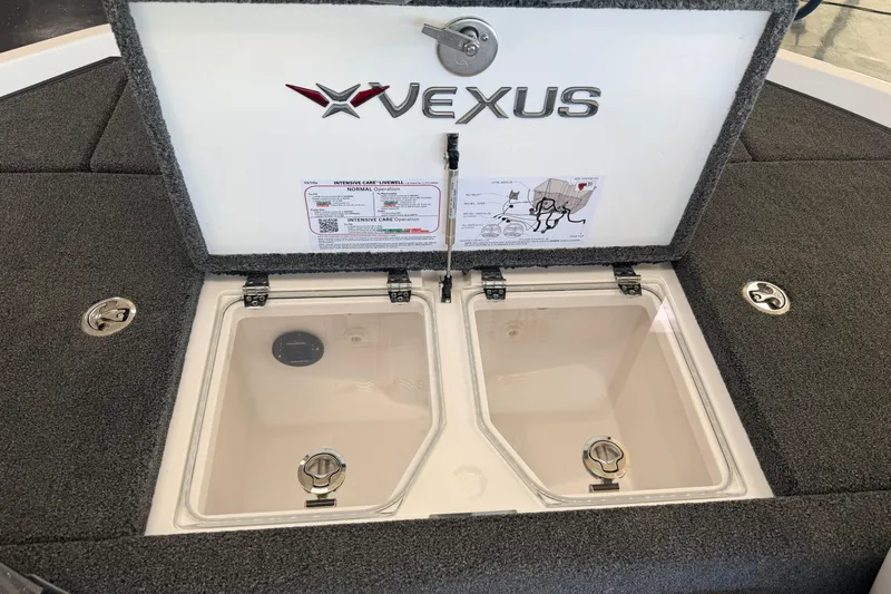 Slide: The Image of 2026 Vexus VXS20 boat livewell compartment with open lid and instructional label. - 24
