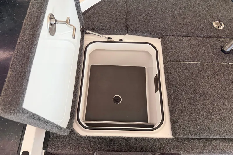 Slide: The Image of Open storage compartment on 2026 Vexus VXS20 boat with gray carpeted deck. - 28