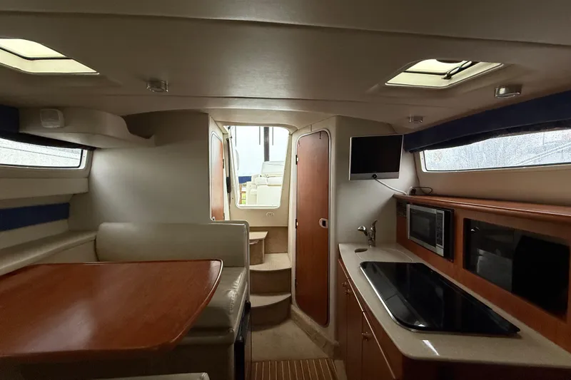 Slide: The Image of Interior of 2009 Bayliner 285 Cruiser with kitchen, dining area, and TV. - 11