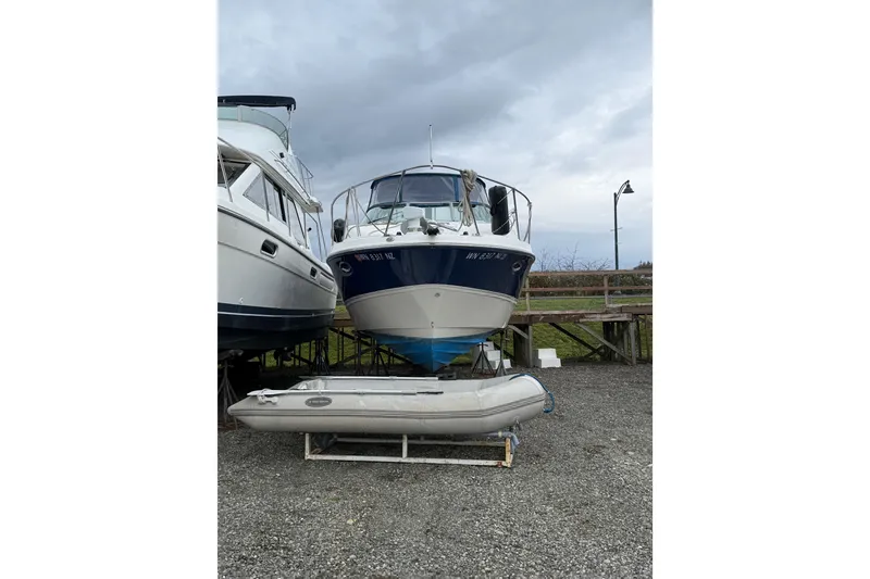 Slide: The Image of 2009 Bayliner 285 Cruiser boat on dry dock with inflatable dinghy in foreground. - 2