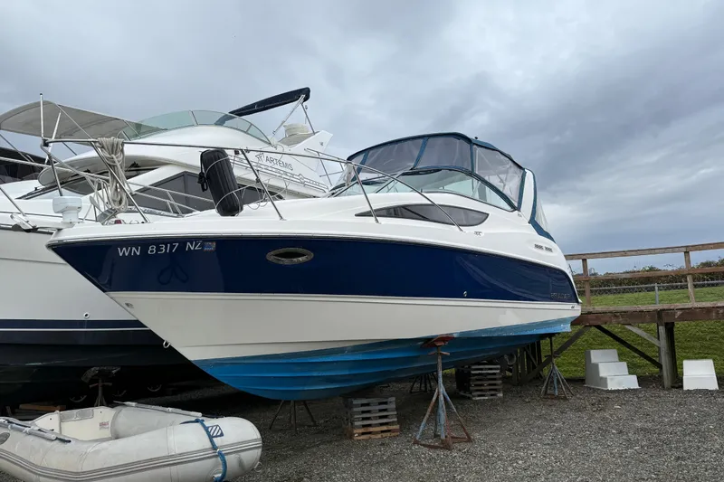 Slide: The Image of 2009 Bayliner 285 Cruiser boat on stands, with overcast sky background. - 3