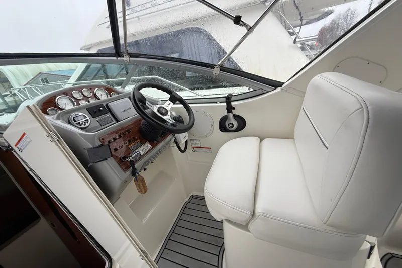 Slide: The Image of 2009 Bayliner 285 Cruiser helm with steering wheel and white captain's seat. - 5