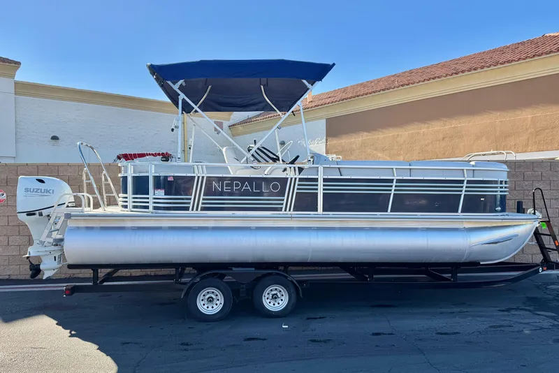 The Image of 2023 Nepallo 22TL pontoon boat with Suzuki engine on trailer, parked outdoors. - 0