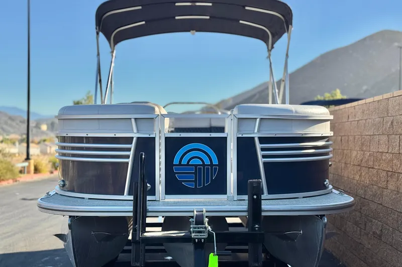 Slide: The Image of 2023 Nepallo 22TL pontoon boat with canopy, parked near mountains. - 2