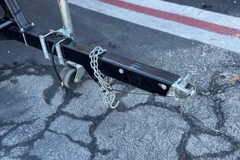Slide: The Image of Trailer hitch of a 2023 Nepallo 22TL with chain on cracked pavement. - 25