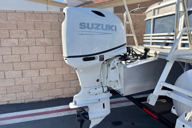 Slide: The Image of 2023 Nepallo 22TL boat with Suzuki outboard motor, parked near a brick wall. - 7