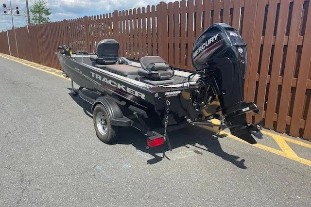 Slide: The Image of 2019 Tracker Panfish 16 boat with Mercury engine on trailer, parked near wooden fence. - 5
