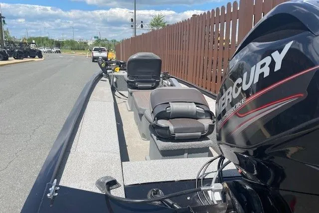 Slide: The Image of 2019 Tracker Panfish 16 boat with Mercury engine, parked near a wooden fence. - 6