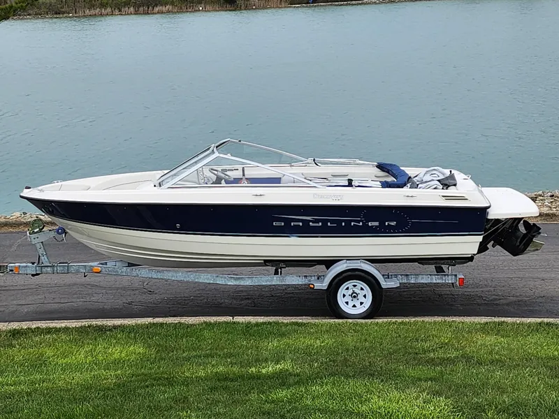 The Image of 2007 Bayliner Discovery 195 boat on trailer by a lake. - 0