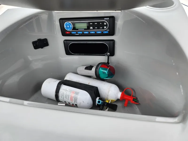 Slide: The Image of 2007 Bayliner Discovery 195 boat storage with fire extinguishers and stereo system. - 15