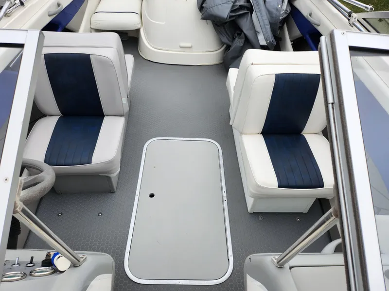 Slide: The Image of 2007 Bayliner Discovery 195 interior with gray flooring and blue-accented seating. - 19