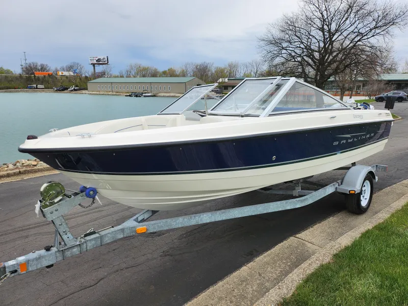 Slide: The Image of 2007 Bayliner Discovery 195 boat on trailer by a lakeside road. - 8