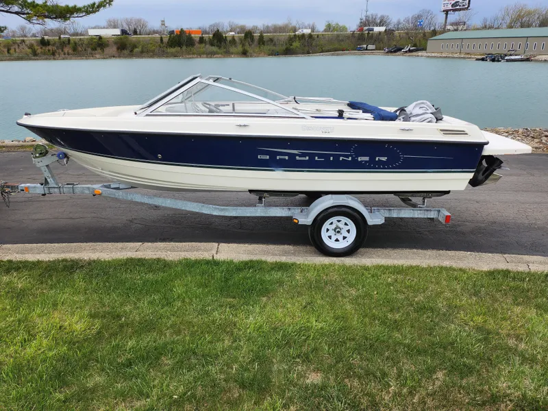 Slide: The Image of 2007 Bayliner Discovery 195 boat on trailer by a lake. - 9