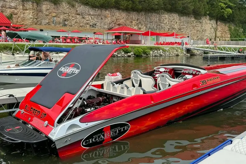 Slide: The Image of 2011 Cigarette 39' Top Gun Unlimited boat on trailer, vibrant red and black design. - 11