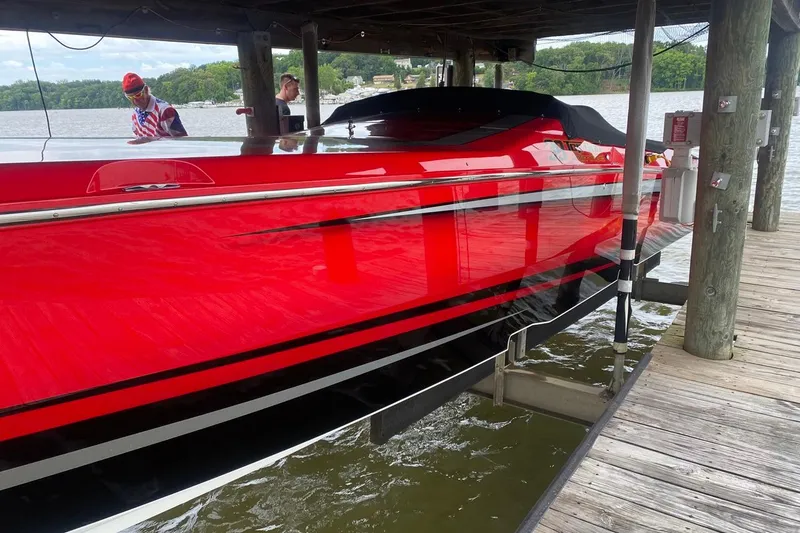 Slide: The Image of 2011 Cigarette 39' Top Gun Unlimited boat in vibrant red on a trailer. - 5