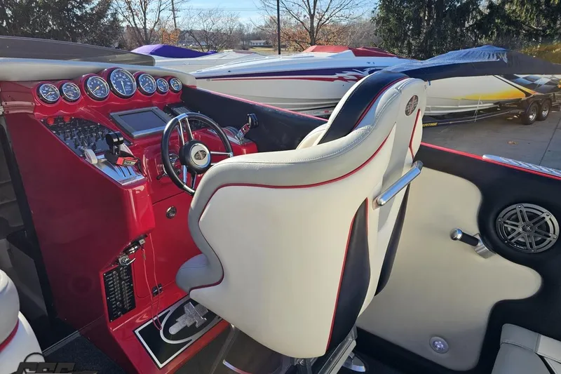 Slide: The Image of Interior of a 2011 Cigarette 39' Top Gun Unlimited boat with red dashboard and gauges. - 55