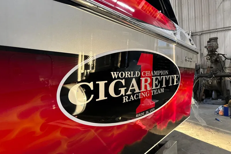 Slide: The Image of 2011 Cigarette 39' Top Gun Unlimited speedboat on trailer, vibrant red design. - 6