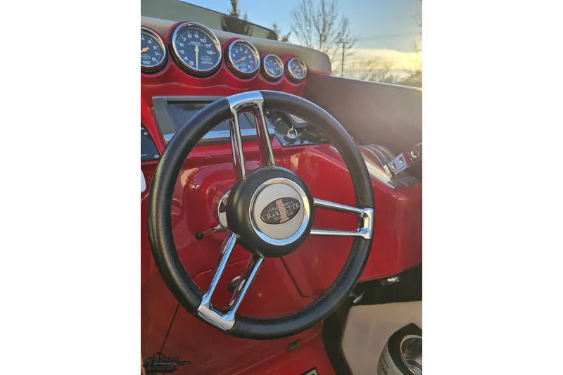 Slide: The Image of Steering wheel of a 2011 Cigarette 39' Top Gun Unlimited boat, featuring red dashboard. - 67