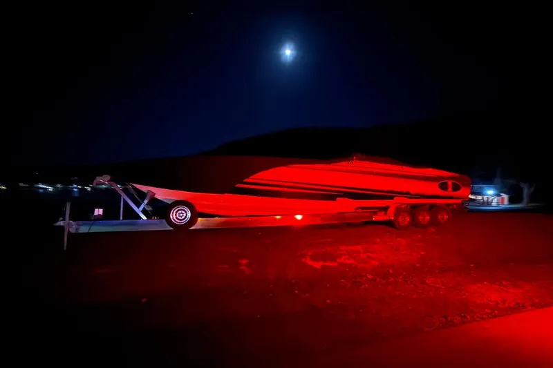 Slide: The Image of 2011 Cigarette 39' Top Gun Unlimited boat on trailer, vibrant red and black design. - 7