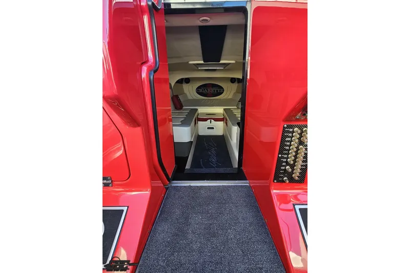 Slide: The Image of 2011 Cigarette 39' Top Gun Unlimited boat interior with red exterior and seating area. - 77