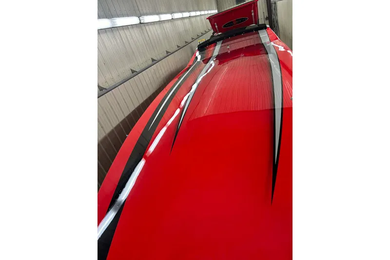 Slide: The Image of 2011 Cigarette 39' Top Gun Unlimited boat with vibrant red and black design on trailer. - 8