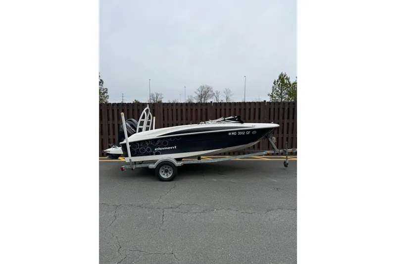 Slide: The Image of 2013 Bayliner Element E16 boat on trailer, parked outdoors. - 1