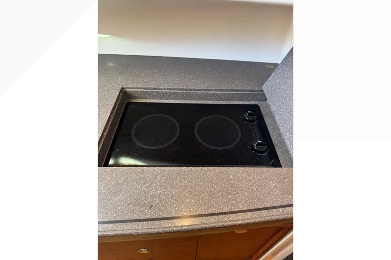 Slide: The Image of Stovetop in 2007 Grady-White Express 360 boat kitchen, featuring sleek countertop design. - 48