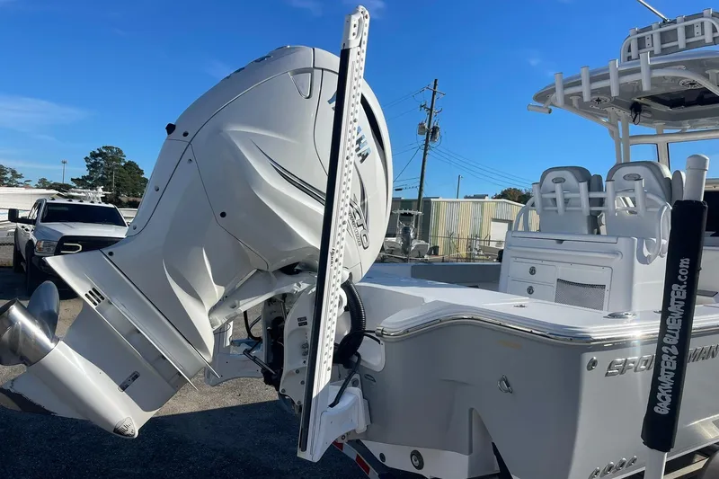 Slide: The Image of 2020 Sportsman Masters 267OE Bay Boat with outboard motor in a parking lot. - 13