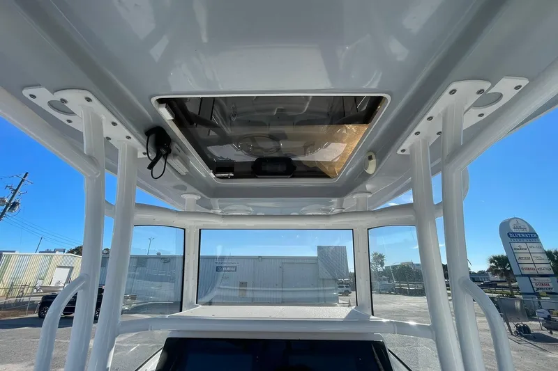 Slide: The Image of 2020 Sportsman Masters 267OE Bay Boat with rod holders and T-top under clear blue sky. - 17