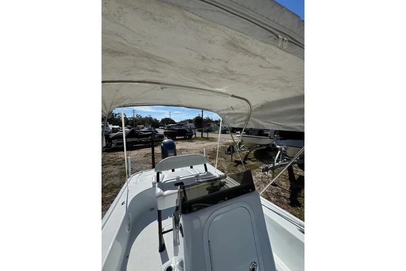 Slide: The Image of 2018 Yellowfin 21 Bay boat interior with canopy, parked outdoors. - 12