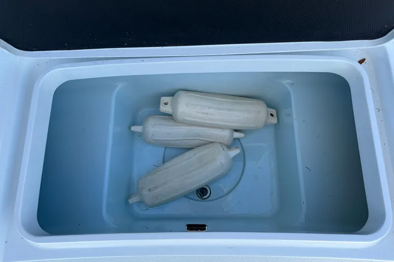 Slide: The Image of Open storage compartment with boat fenders in a 2018 Yellowfin 21 Bay. - 23