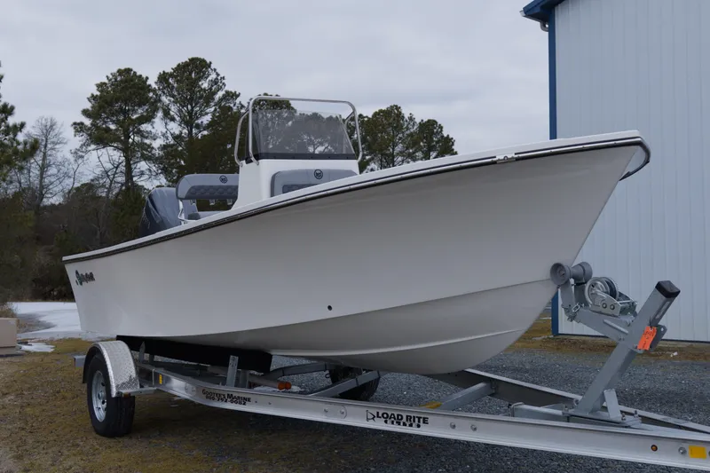 Slide: The Image of 2026 May-Craft 208 CC boat on trailer, parked outdoors near trees and building. - 10