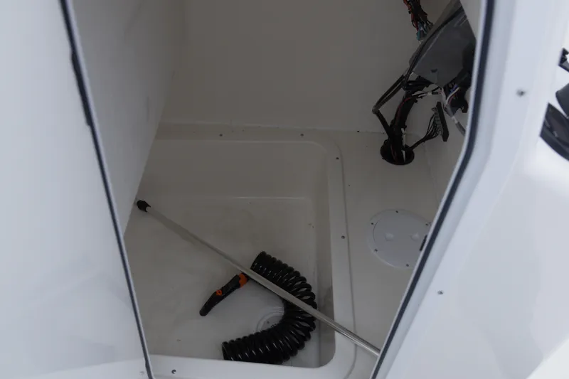 Slide: The Image of Interior of 2026 May-Craft 208 CC boat showing storage compartment and coiled hose. - 16