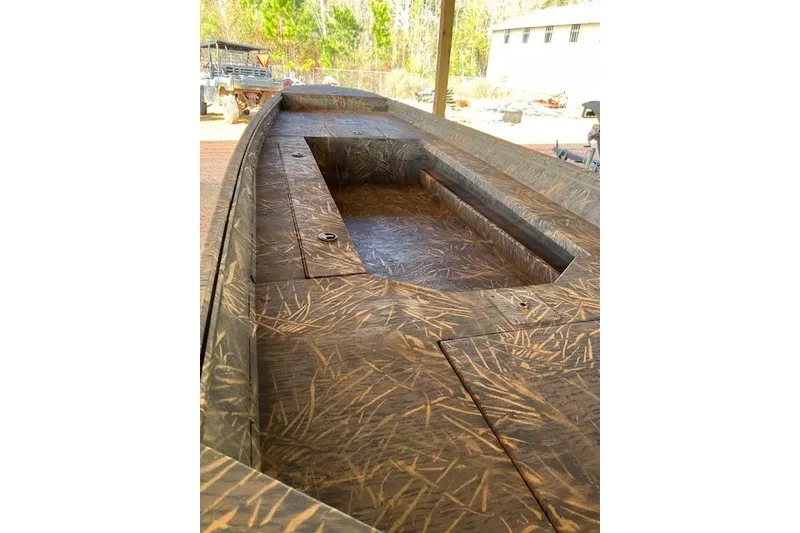 Slide: The Image of 2026 G3 Gator Tough 17 DK boat with camouflage pattern, parked outdoors. - 2