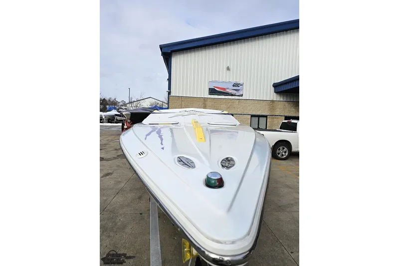 Slide: The Image of 2003 Baja 25 Outlaw boat displayed outside a building on a trailer. - 15