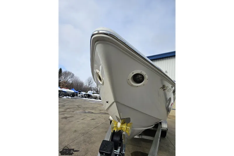 Slide: The Image of 2003 Baja 25 Outlaw boat on trailer, parked outdoors on a cloudy day. - 16