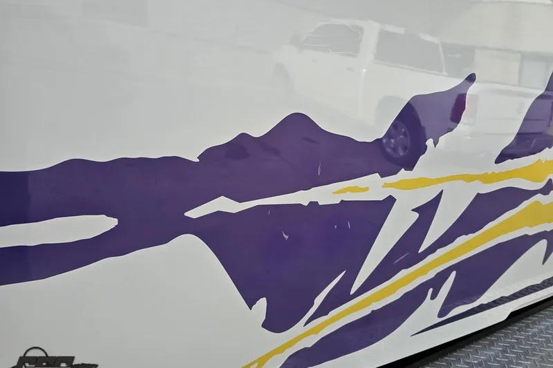 Slide: The Image of 2003 Baja 25 Outlaw boat with vibrant purple and yellow graphics. - 27