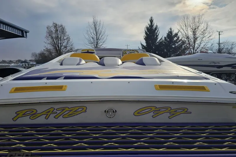Slide: The Image of 2003 Baja 25 Outlaw boat with custom "Paid Off" graphics, docked outdoors. - 33
