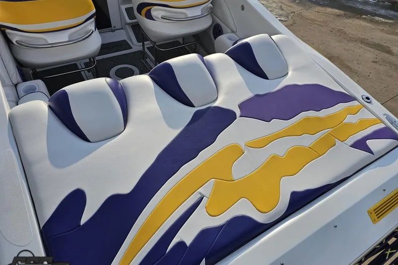 Slide: The Image of 2003 Baja 25 Outlaw boat interior with vibrant yellow, purple, and white upholstery design. - 35