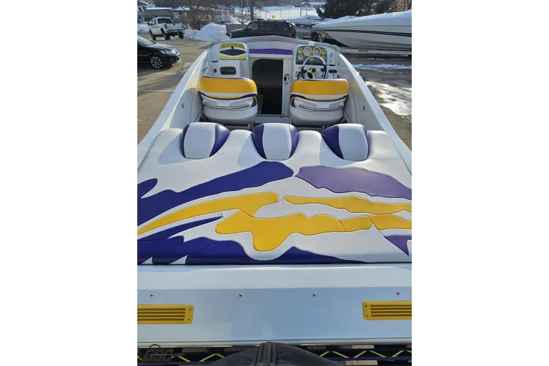 Slide: The Image of 2003 Baja 25 Outlaw boat with vibrant yellow and purple seating design. - 36