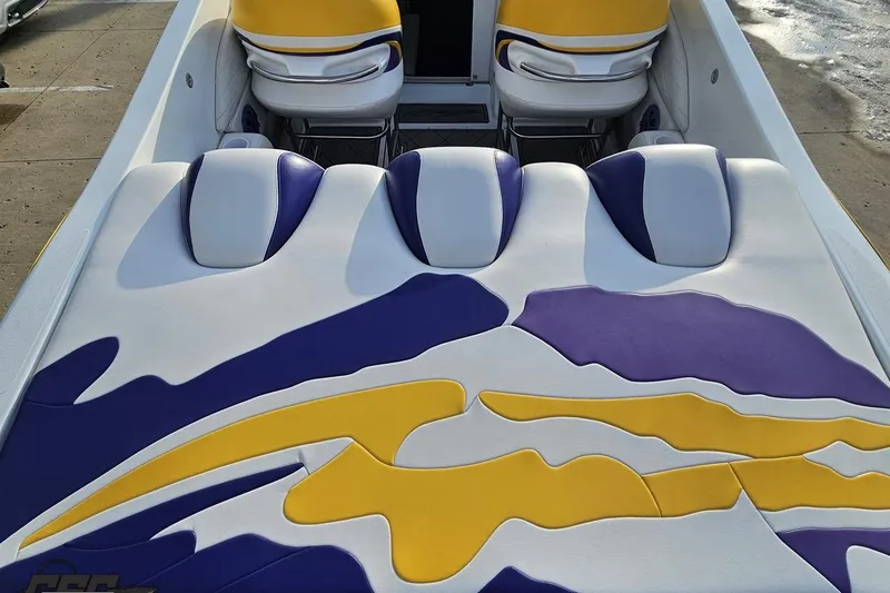 Slide: The Image of 2003 Baja 25 Outlaw boat interior with vibrant yellow, purple, and white upholstery design. - 37