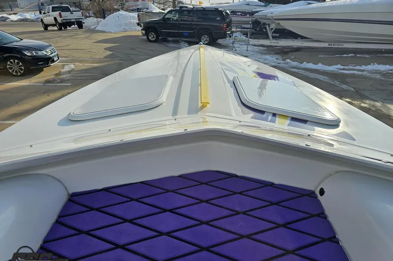 Slide: The Image of 2003 Baja 25 Outlaw boat with purple deck accents in a snowy parking lot. - 39