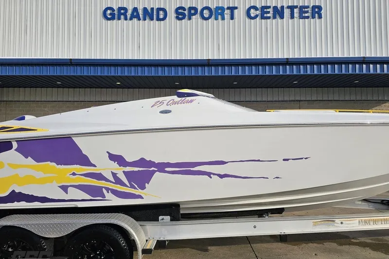 Slide: The Image of 2003 Baja 25 Outlaw boat with vibrant purple and yellow graphics at Grand Sport Center. - 4