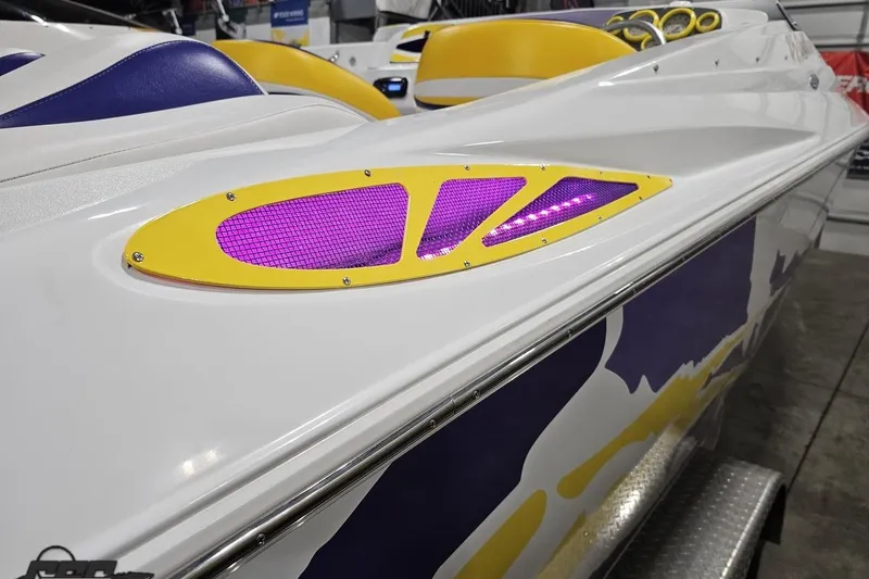 Slide: The Image of 2003 Baja 25 Outlaw boat with vibrant yellow and purple accents on the deck. - 42