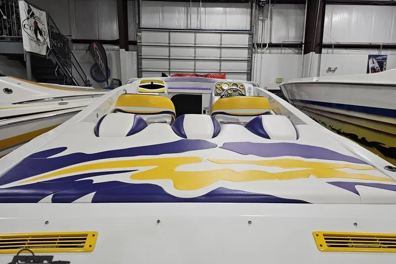 Slide: The Image of 2003 Baja 25 Outlaw boat with vibrant yellow and purple interior design in a showroom. - 46