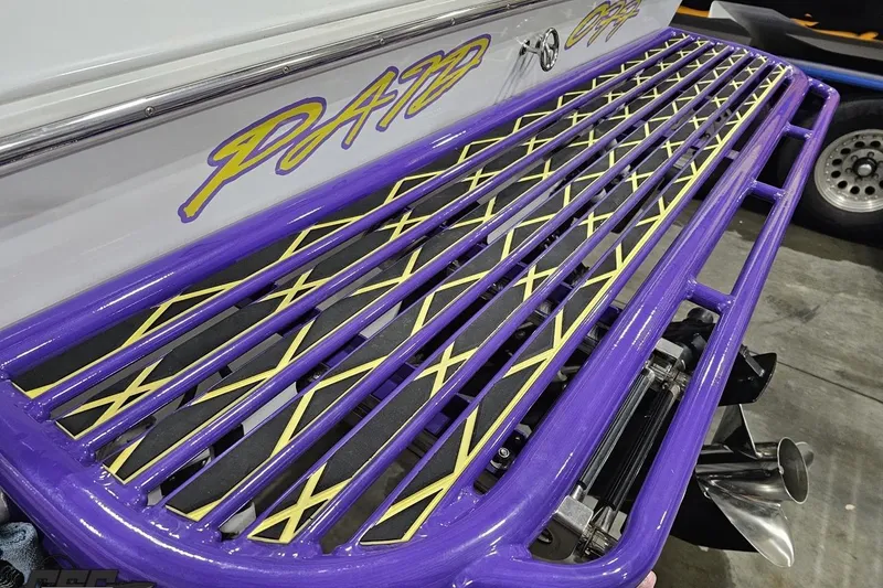 Slide: The Image of 2003 Baja 25 Outlaw boat with vibrant purple and yellow detailing. - 47
