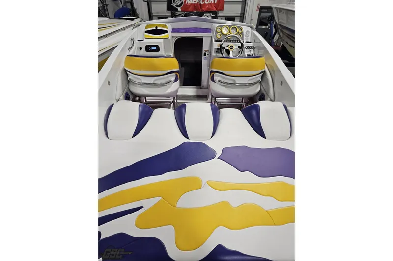 Slide: The Image of 2003 Baja 25 Outlaw boat interior with vibrant yellow and purple seating design. - 48