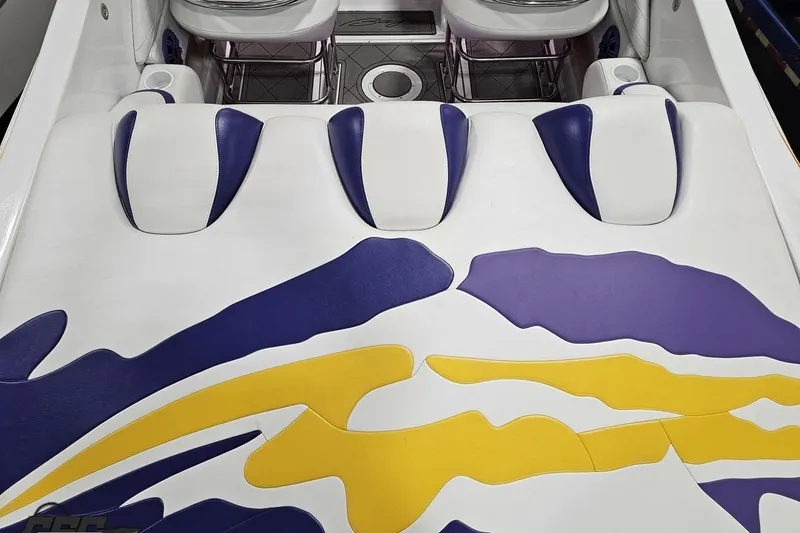 Slide: The Image of 2003 Baja 25 Outlaw boat interior with vibrant purple and yellow upholstery design. - 49