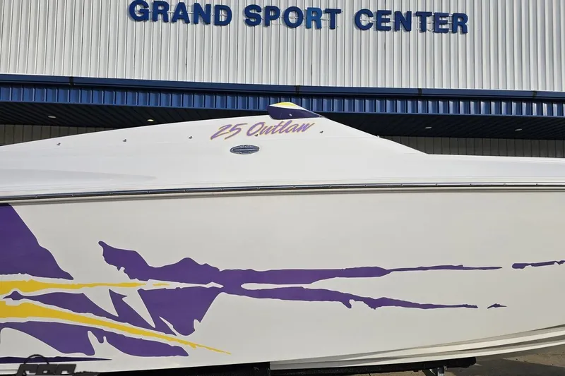 Slide: The Image of 2003 Baja 25 Outlaw boat with purple graphics at Grand Sport Center. - 5